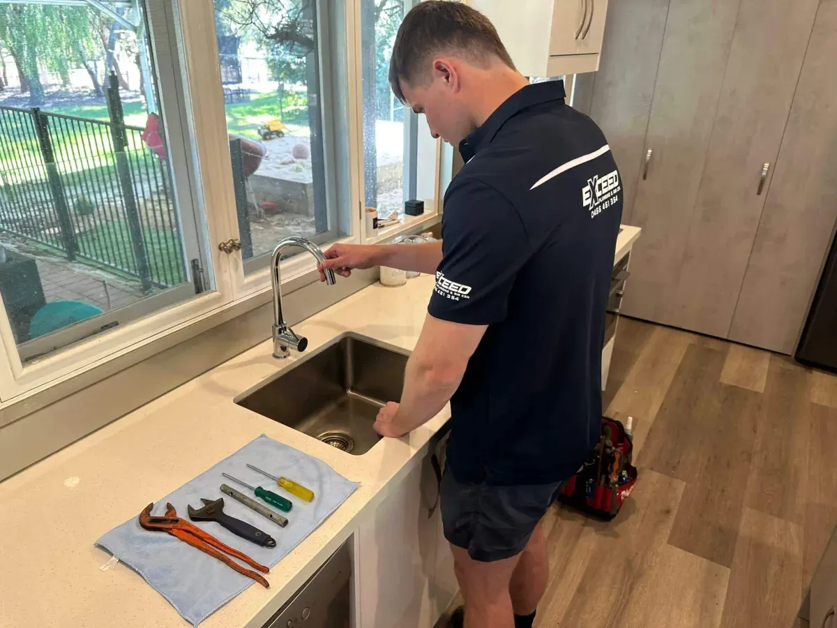 Professional plumber installing hot water system